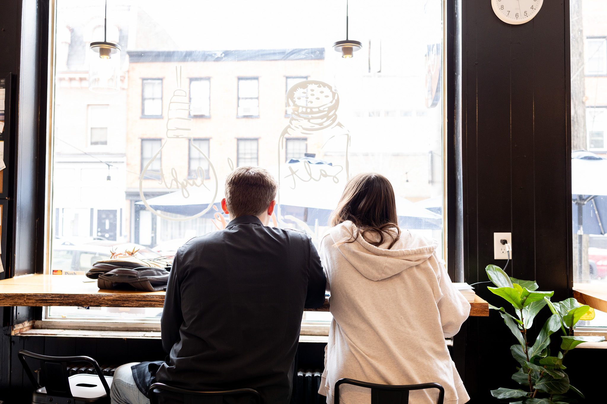 a couple sitting at the window drinking coffee